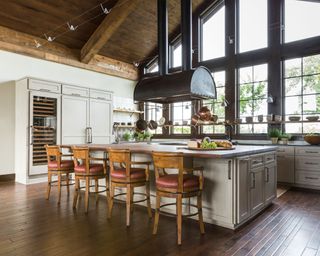 Large kitchen with wooden vaulted ceiling, large island with bar seating, large windows, gray kitchen cabinets