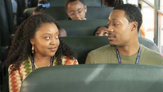 Janine and Gregory sitting together and smiling in a school bus on Abbott Elementary