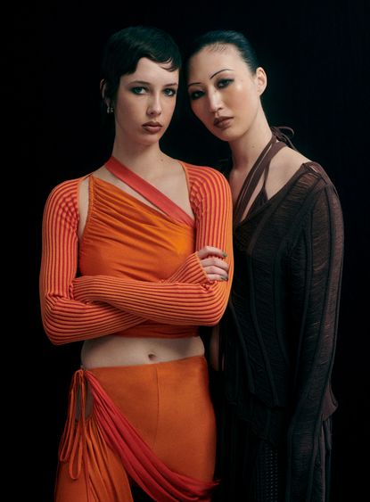 Two women wearing strappy clothes by Andreadamo