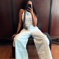 woman wearing white tank and white wide jeans with sneakers summer 2025 outfit