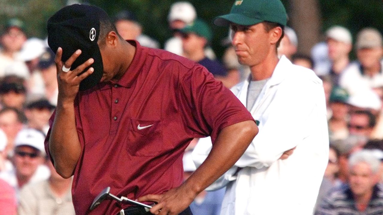 Tiger Woods pulls his cap over his face after a missed putt