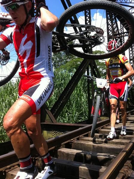 Alexander Sanchez leads Todd Wells across the railroad bridge