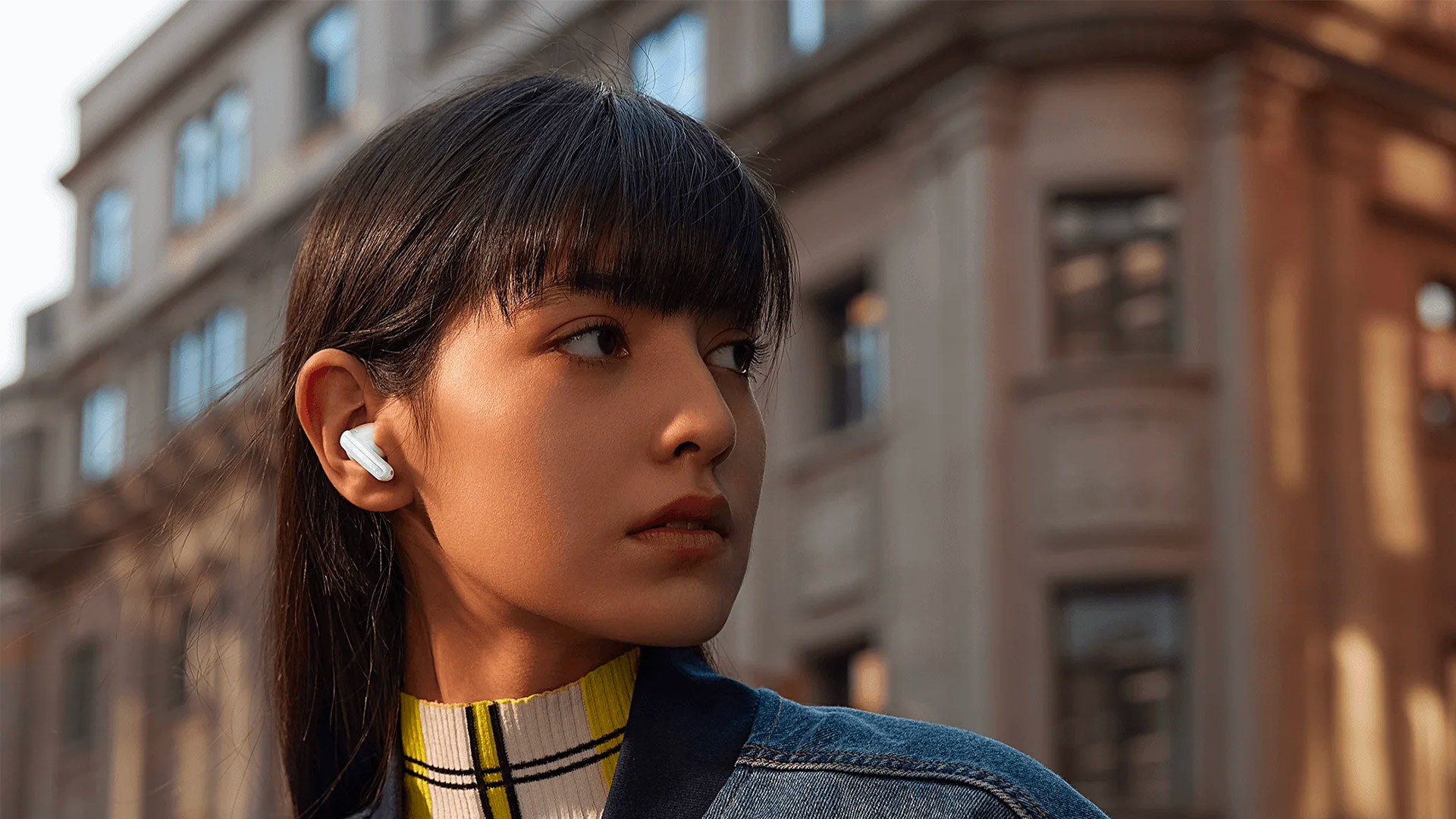 The Xiaomi Buds 5 Pro being worn by a model