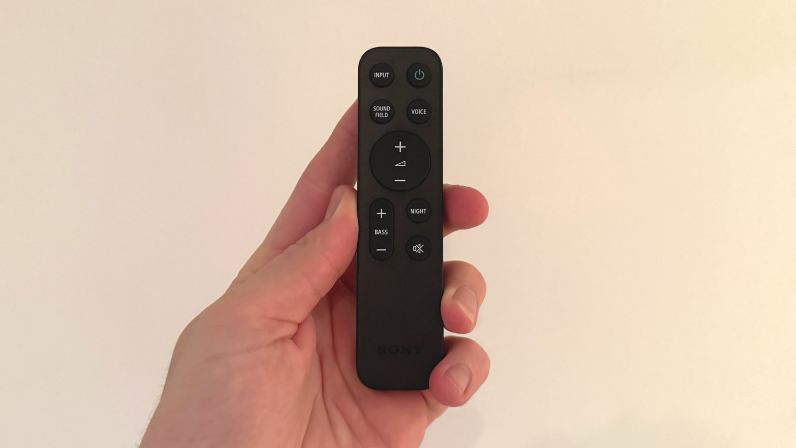 Picture of the remote control supplied with the Sony Bravia Theater Bar 8 soundbar, being held in a hand