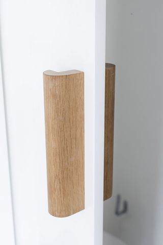 the design of the shelf and the wall-mounted mirror’s wooden bracket