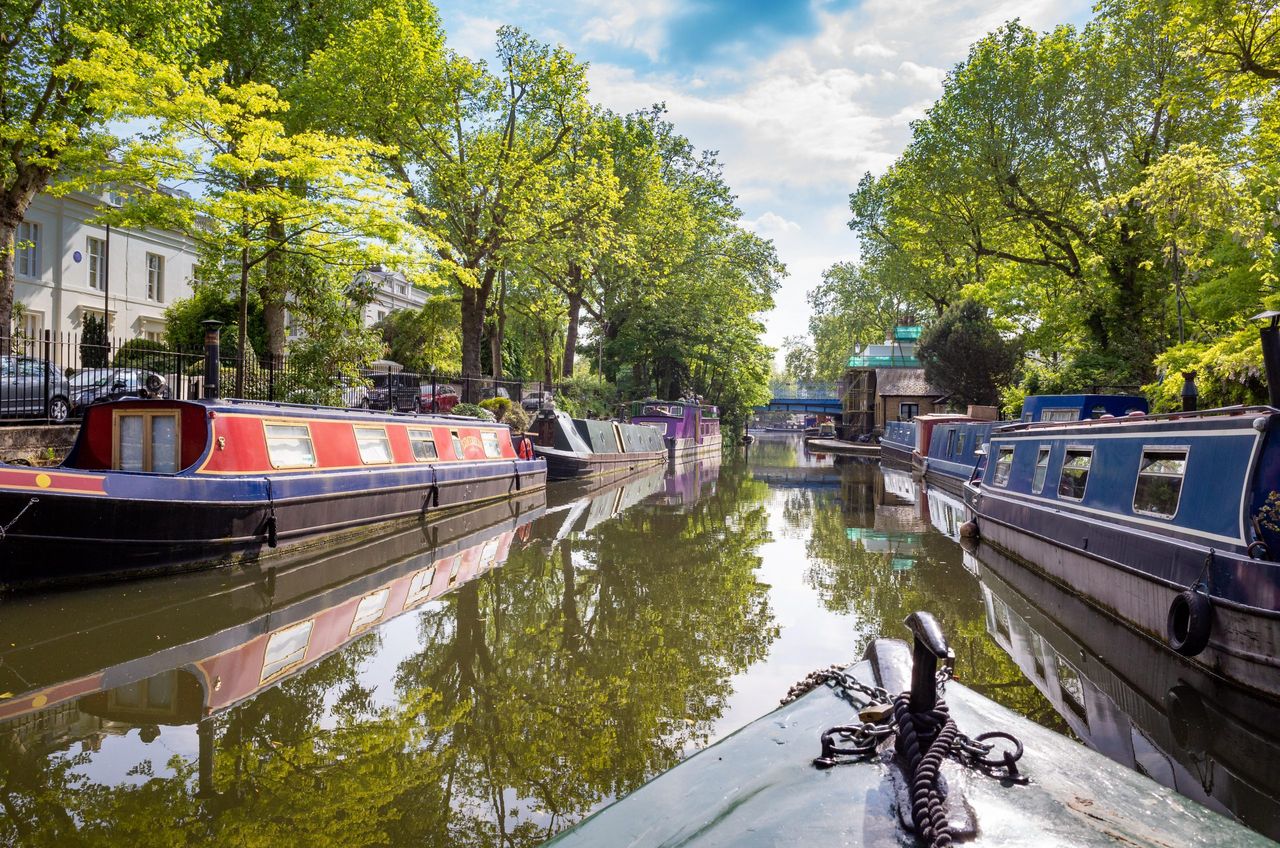 Where could you get these views at these prices? A narrowboat travelling past the houseboats of Little Venice on the Regent&#039;s Canal, London.