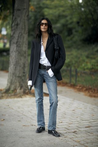 woman wearing blazer, button-down shirt, and jeans