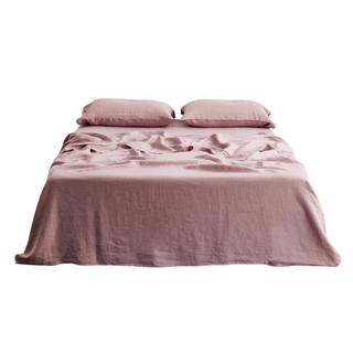 A pink linen flat sheet on a bed