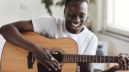 Man playing guitar sitting down