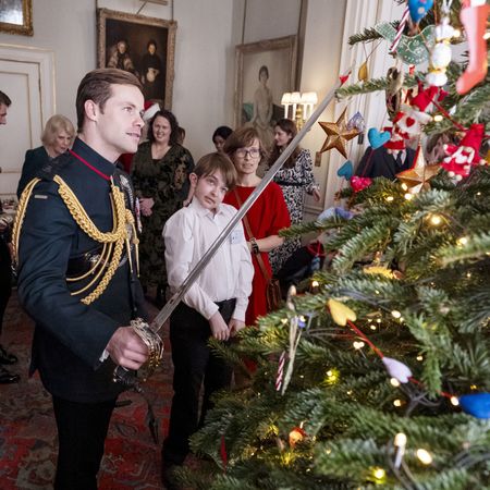 Major Rob Treasure decorating a tree with a sword