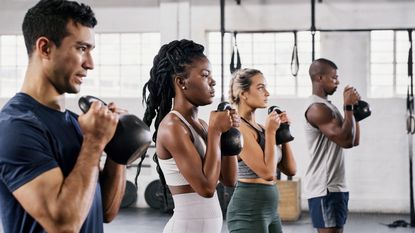 Exercise class holding kettlebells