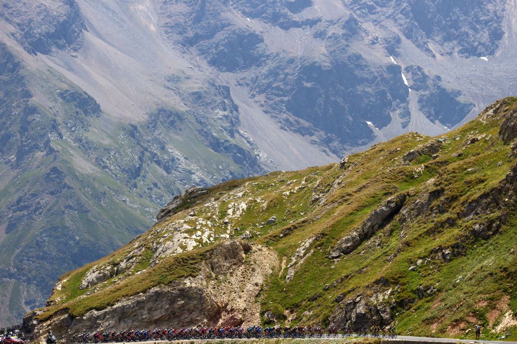 ALPE DHUEZ FRANCE JULY 14 A general view of Wout Van Aert of Belgium Green Points Jersey Jonas Vingegaard Rasmussen of Denmark and Team Jumbo Visma Yellow Leader Jersey and the peloton compete beginning to climb the Col du Lautaret 2056m mountain landscape during the 109th Tour de France 2022 Stage 12 a 1651km stage from Brianon to LAlpe dHuez 1471m TDF2022 WorldTour on July 14 2022 in Alpe dHuez France Photo by Michael SteeleGetty Images