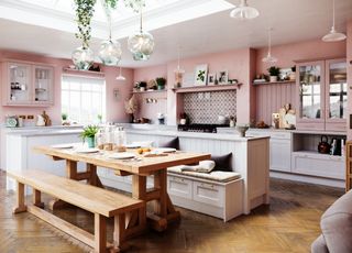 A large kitchen with pink painted walls, glass pendant lights, wooden floors