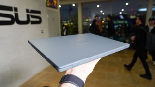 Asus Zenbook A14 closed balanced on a person's hand