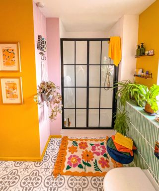 bathroom with crittall style shower screen, yellow walls, patterned tile floor and walls - overatno18