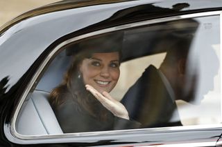 Britain's Catherine, Duchess of Cambridge waves from a car as she and Britain's Prince William, Duke of Cambridge, leave after attending the Easter Mattins Service at St. George's Chapel, Windsor Castle on April 1, 2018.