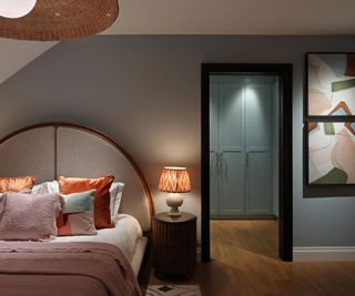 bedroom with walk in dressing room and curved headboard