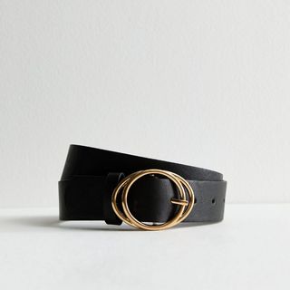 A close up of a belt with a gold buckle on a white background