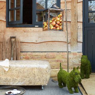 ingenious straw bale seat with stainless steel lantern moss schnauzer and moss scottie dune weave outdoor rug