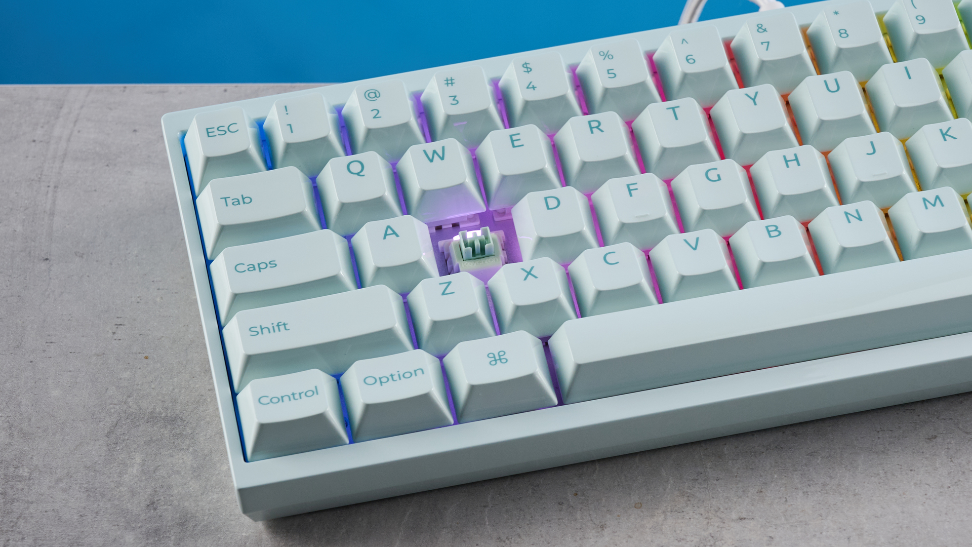 The Keychron Q16 HE 8K in light green on a stone surface