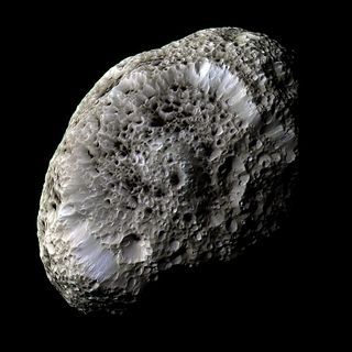 Saturn's moon Hyperion possesses many craters, most of which contain an unknown dark material. This 2005 Cassini image shows the strangely-textured surface. Hyperion measures about 150 miles (250 km) across, rotates chaotically, and has a density so low t