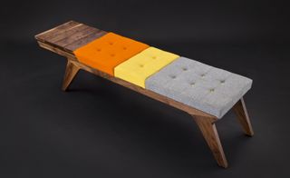 Bench made of dark wood, with grey, yellow and orange upholstery