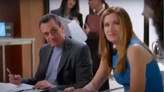 Hank Azaria and Kathryn Hahn sit at a conference table with looks of disapproval in Free Agents.