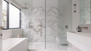 A marble bathroom with a walk in shower and a freestanding bath tub