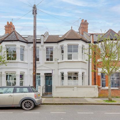 sloping roof house with white walls and chimney stacks