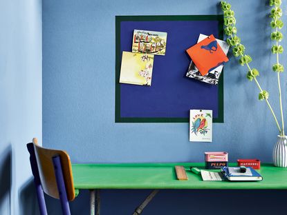 home office with blue walls and blue notice board