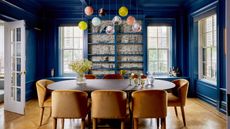 blue dining room with bauble lights and gold chairs