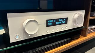 JBL MA310 AVR in white on a media unit shelf