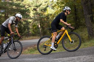 Cyclist in black riding Scott Addict RC on green background