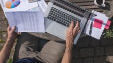 Arial view of a man working on a laptop on a table outside.