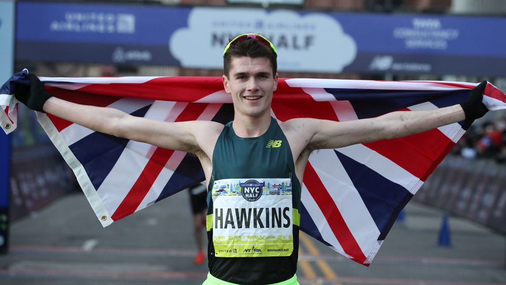 Callum Hawkins in race vest holding Union Jack flag