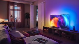 The Philips OLED807 on display in a living room - the wall behind it is light up by the Ambilight feature