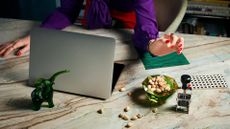 Desk with open computer and office essentials, plus bowl of nuts and a glass ornament