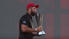Jon Rahm carries the LIV Golf Individual Championship trophy after winning in 2025