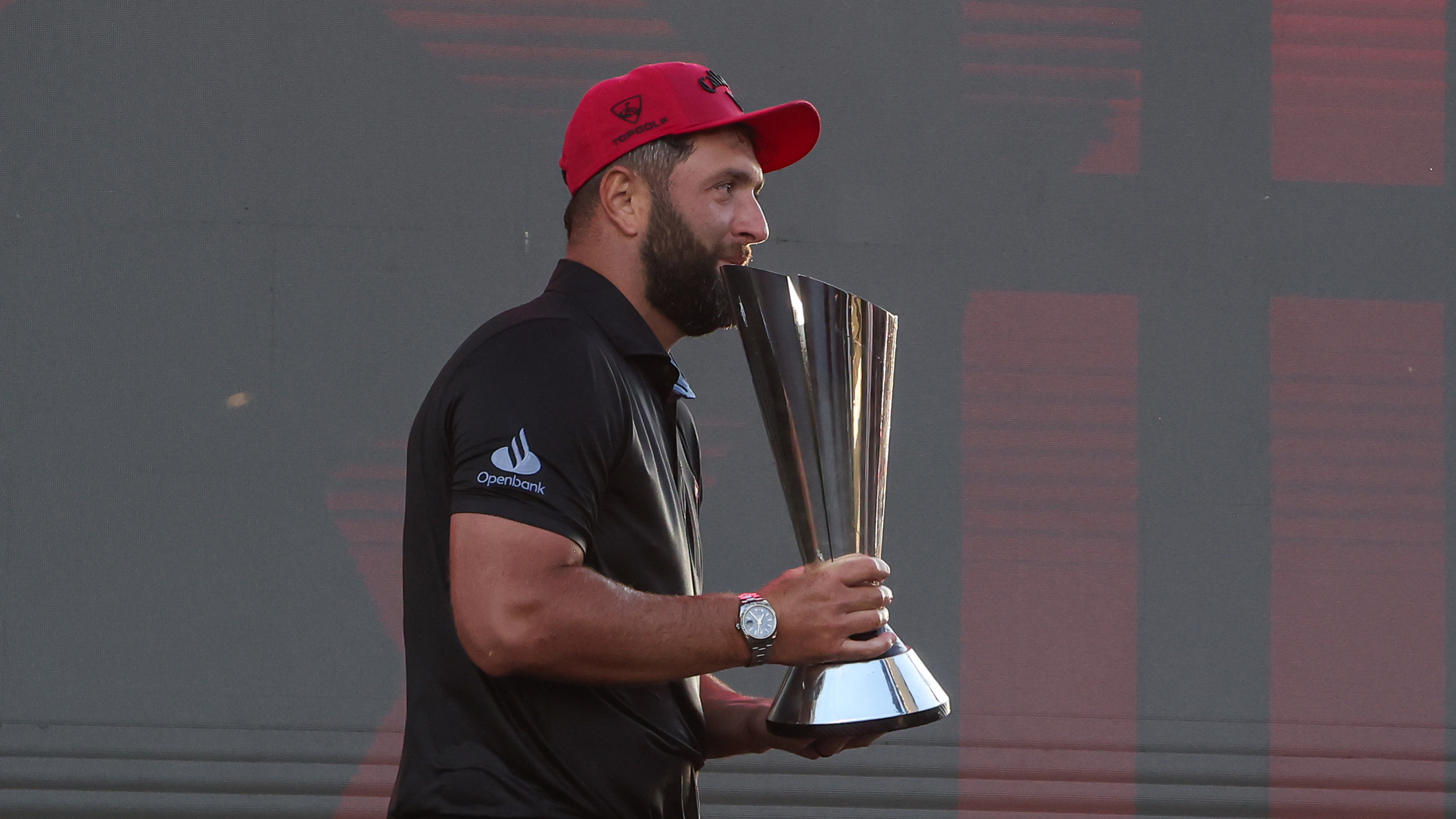 Jon Rahm carries the LIV Golf Individual Championship trophy after winning in 2025