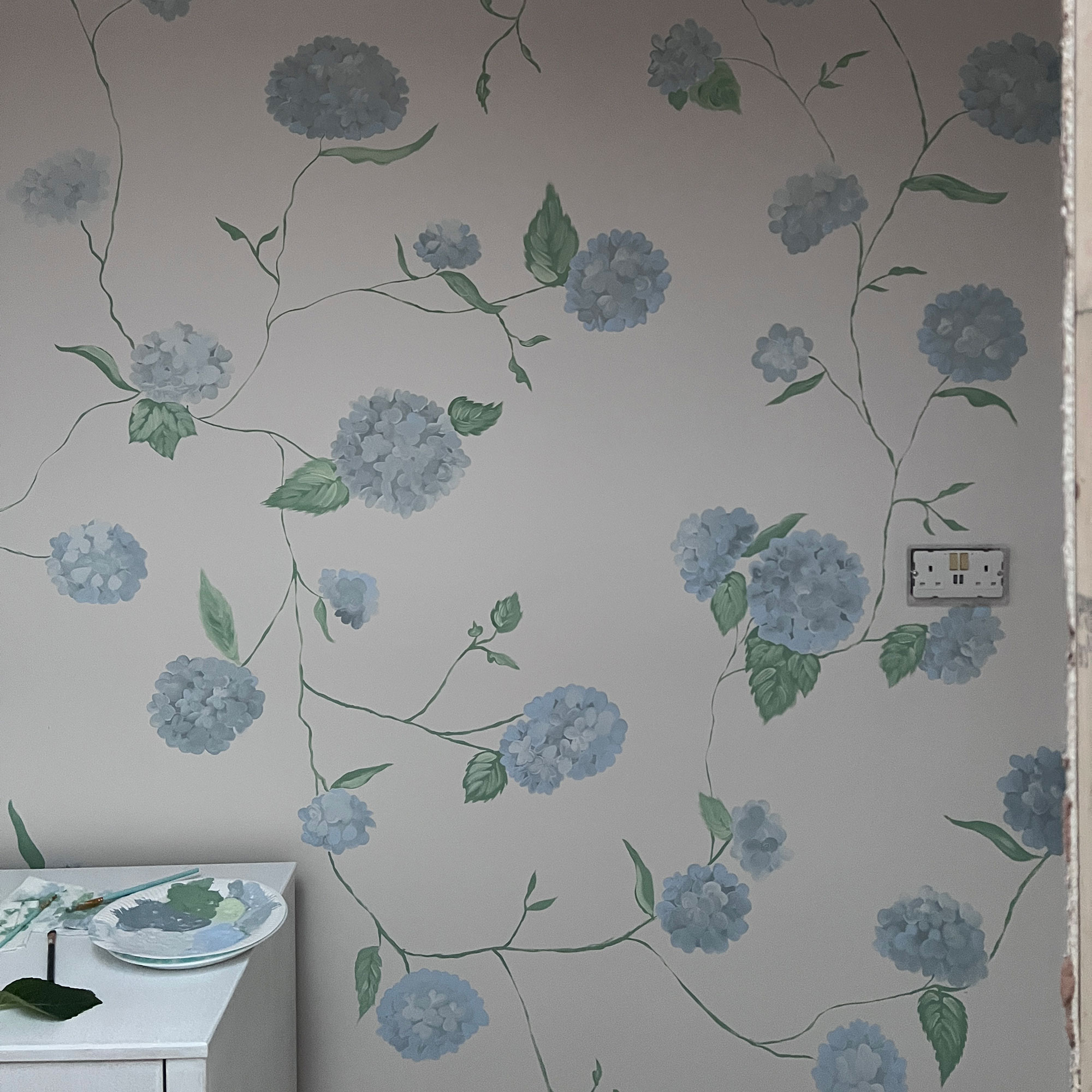 White wall with blue hydrangea painted pattern