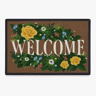 A brown mat that says 'welcome' with floral illustrations