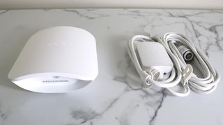 An Eero Outdoor 7 mesh extender with an AC adapter