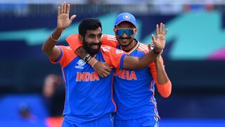 Axar Patel (R) and Jasprit Bumrah (L) in India's blue and orange strip celebrating on-field at the T20 World Cup 2024.
