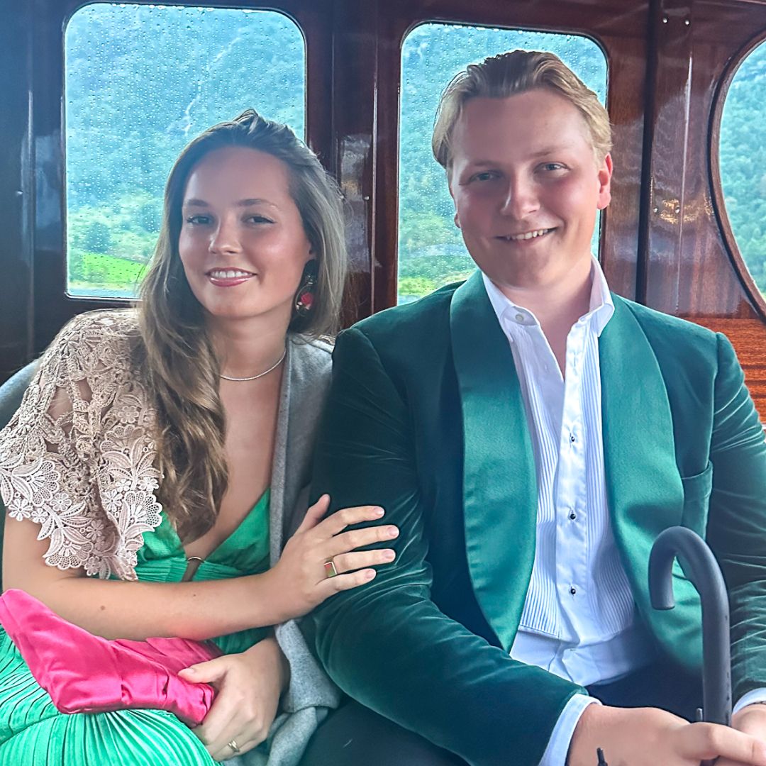 A photo of Princess Ingrid Alexandra wearing a green gown smiling and holding her brother&#039;s arm while riding inside a wooden boat