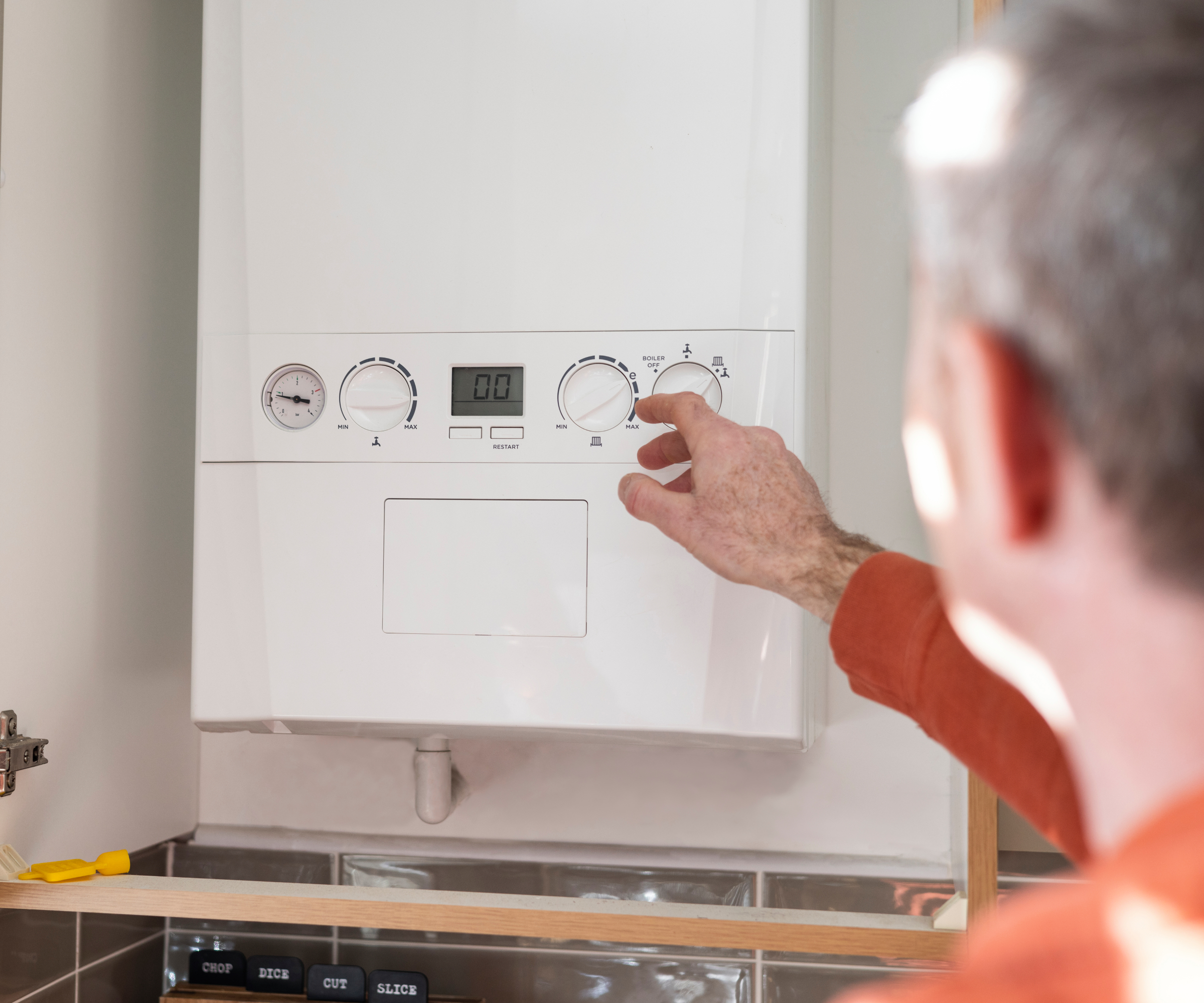 hand reaching to adjust boiler controls