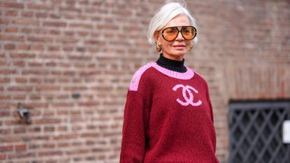 Best concealer for mature skin - Grece Ghanem wears sunglasses, golden earrings, a black turtleneck pullover , a pink and red Chanel pullover getty 1976105865