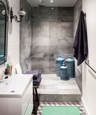 Walk-in shower with step up and grey stone tiles