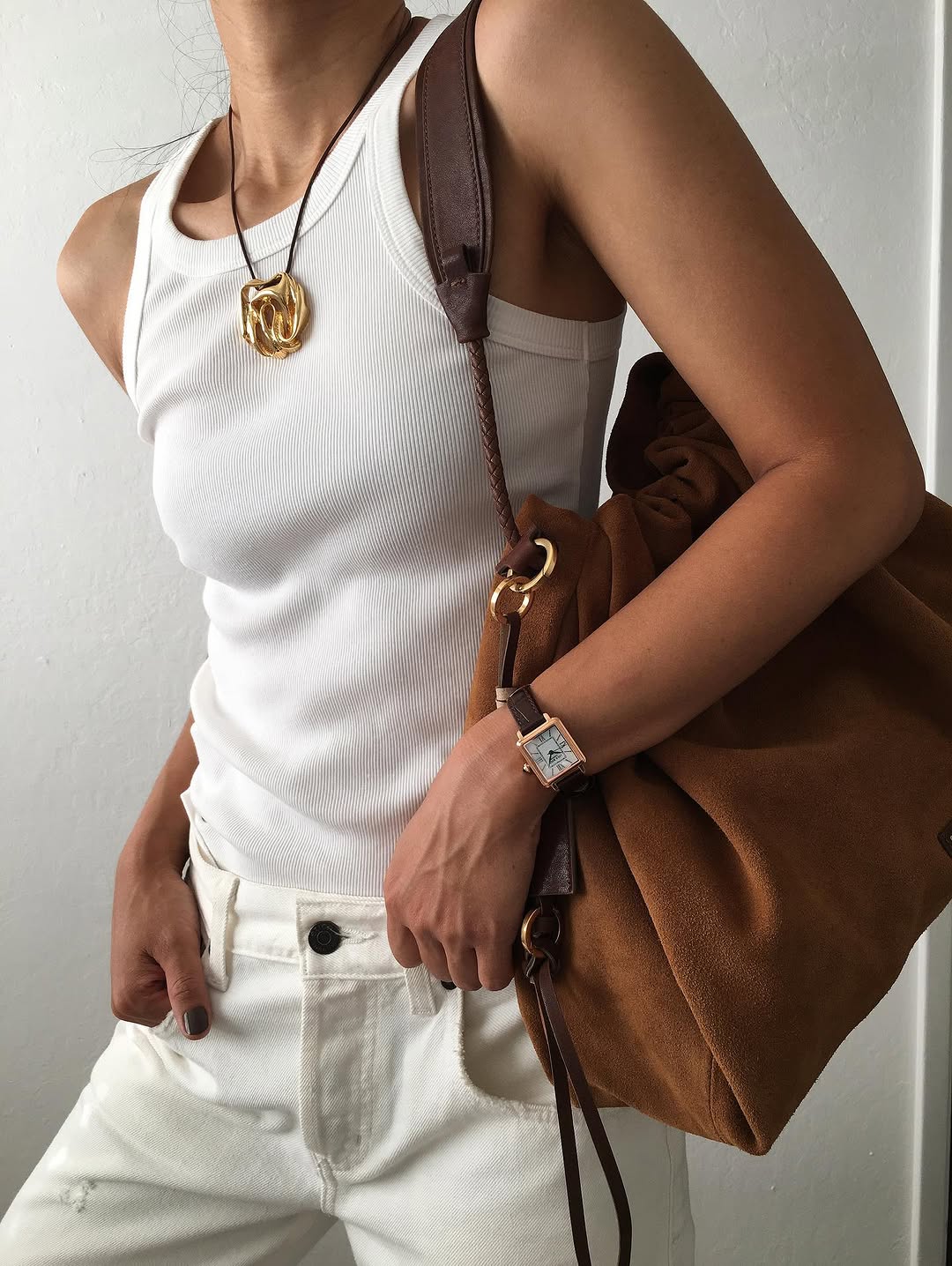 Woman wearing fall brown suede bag trend.
