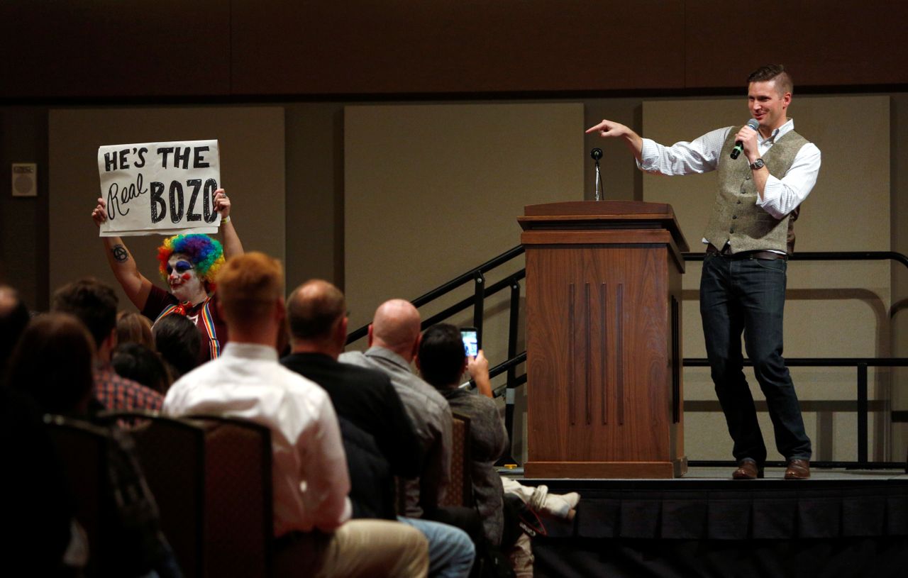 White nationalist leader Richard Spencer speaks on the Texas A&amp;amp;M University campus as a silent protester holds a placard in College Station, Texas.