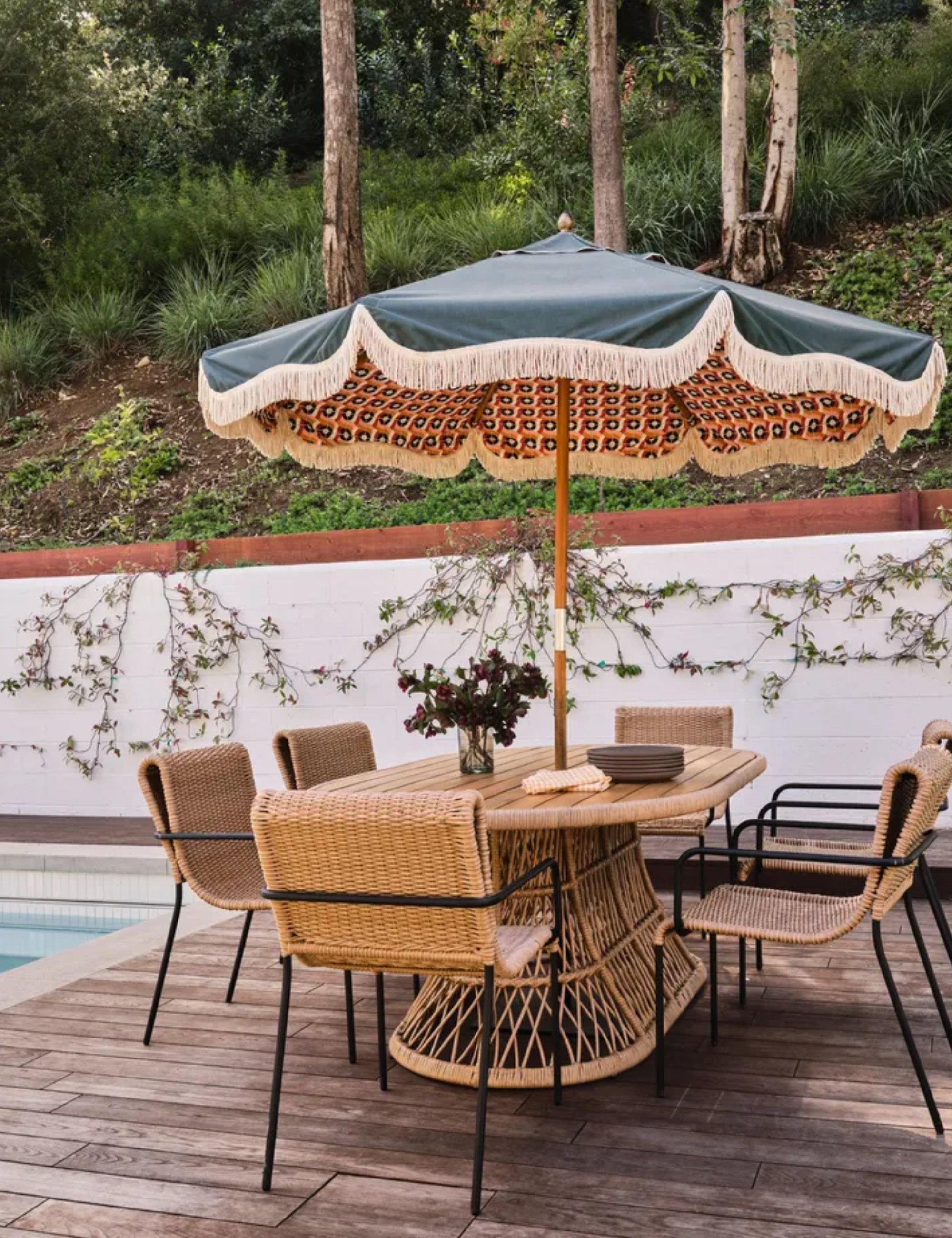 poolside patio with parasol and rattan furniture
